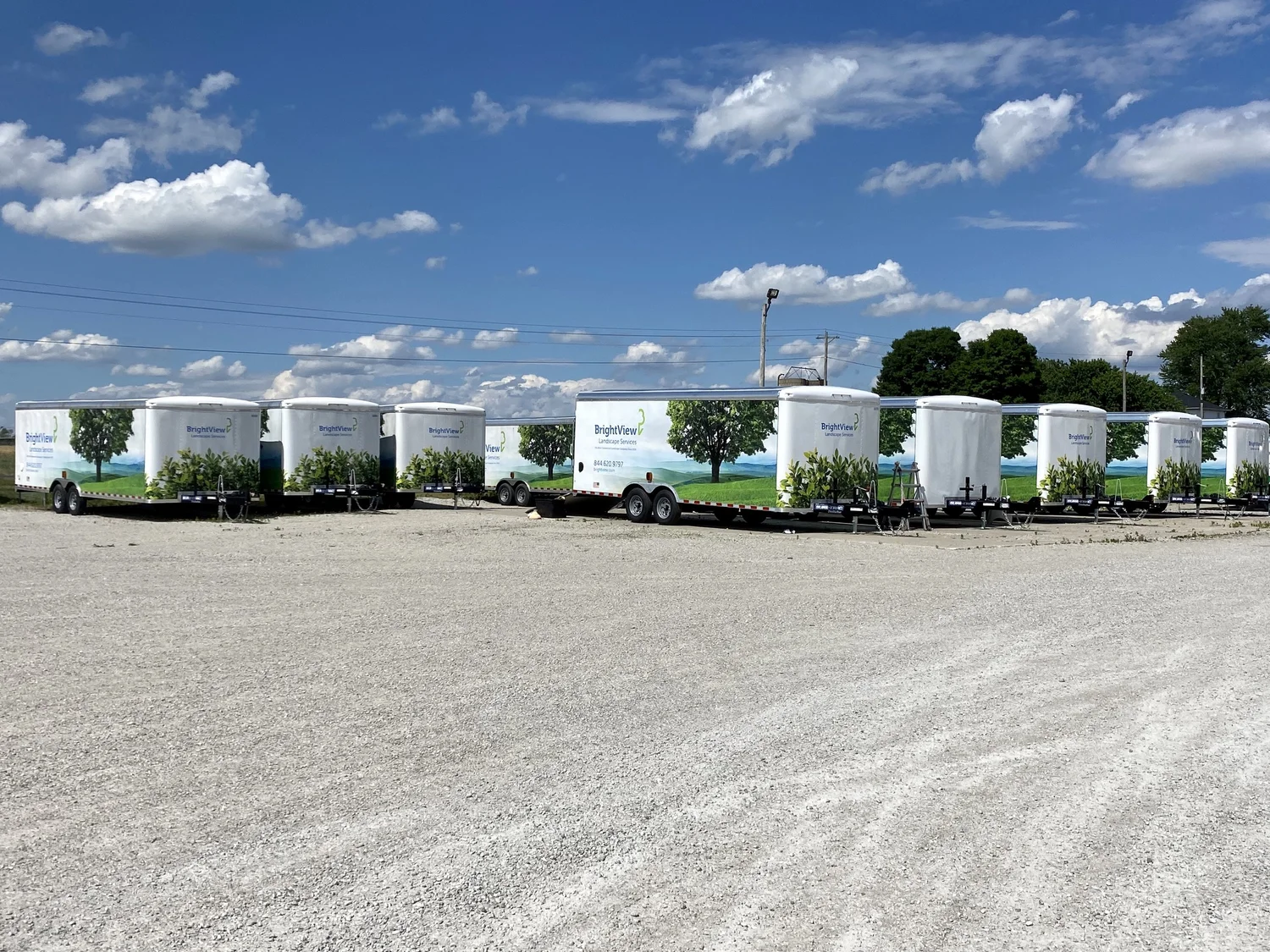 A fleet of BrightView trailers with matching landscape graphics